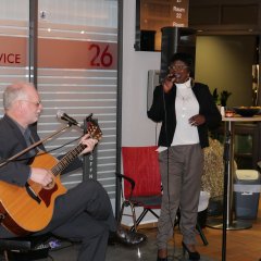 „Patamoto“ mit Florence Viereck, farbige Sängerin mit Mikrophon in der Hand, und Frank Sommerfeld, sitzend mit Gitarre, sorgte für die musikalische Umrahmung der Vernissage. 