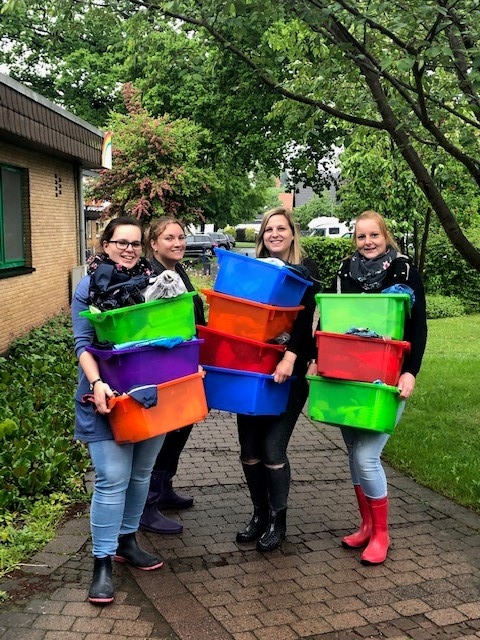 Die Erzieherinnen räumen Spielzeug von Haus B ins Haus A.