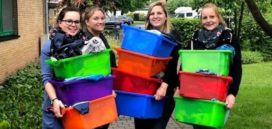 Die Erzieherinnen räumen Spielzeug von Haus B ins Haus A.
