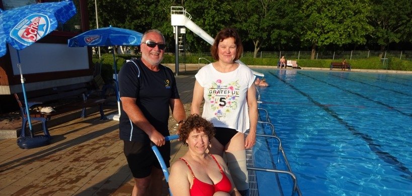 Schwimmmeister Klaus Günther, Sabine Wagner Sprecherin des AK und Susanne Wagner Krah beim Test des neuen Rollis.