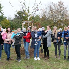 Ein Teil der über 30 Kinder, die am 23.10. bei der Pflanzung ihres Geburts-Apfelbaumes dabei waren mitsamt ihren Eltern und den Äpfeln mit den guten Wünschen, die der Bürgermeister Uwe Jäger an alle Gäste verteilte.  