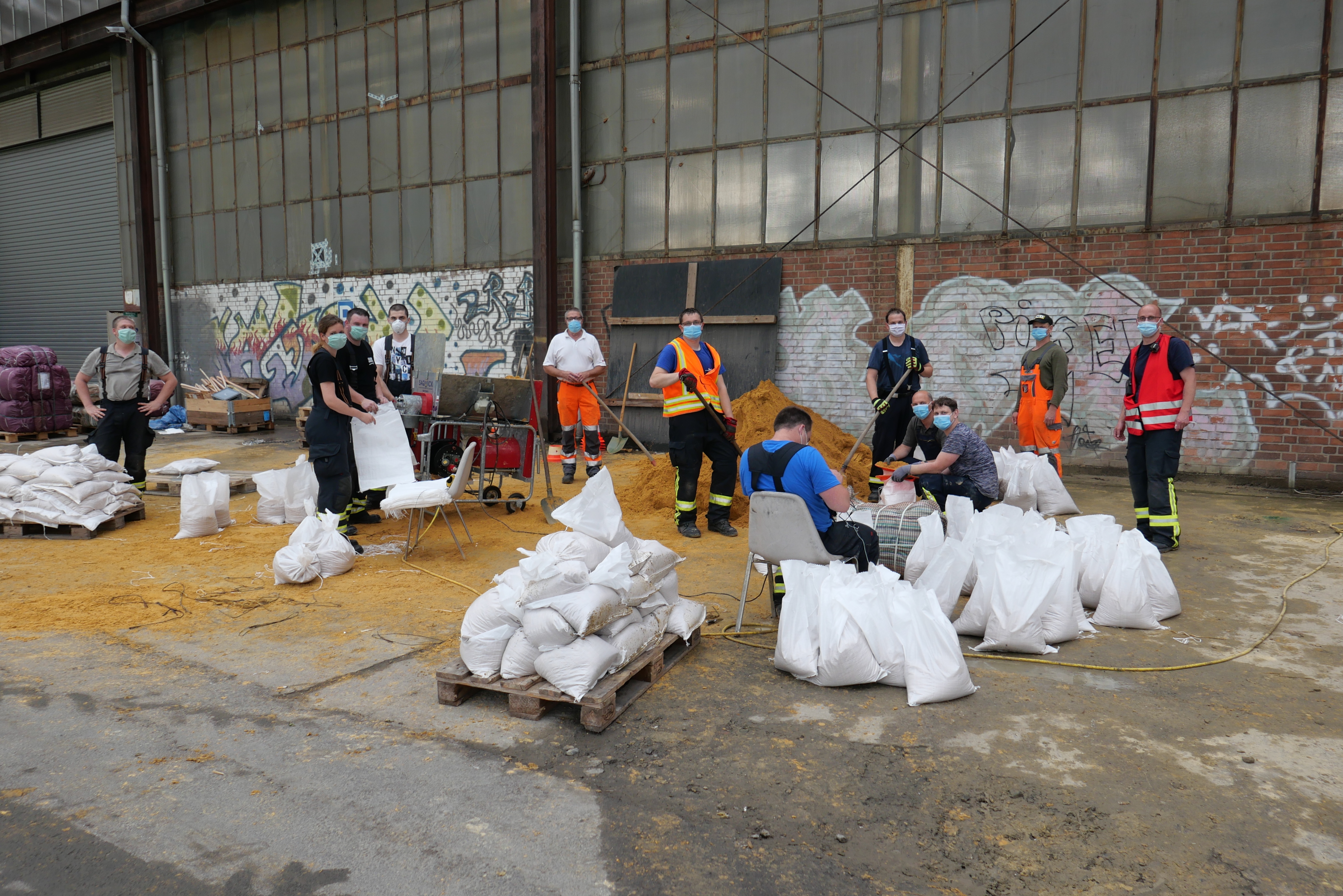 Mit vereinten Kräften befüllten die Mitglieder der Freiwilligen Feuerwehren Lohfelden, Söhrewald und Fuldabrück Sandsäcke für die Gemeinde Nieste, in der es am 15.06. zu heftigen Überflutungen aufgrund des Starkregenereignisses kam, auf dem Gelände der ehemaligen Richterhallen.