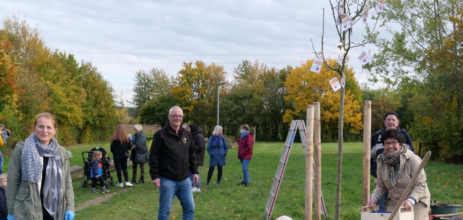Freuten sich, als der Apfelbaum erfolgreich eingepflanzt war (v.l.n.r.): Danica Wurmbach, die für das Projekt zuständige Mitarbeiterin aus dem Fachbereich Bauen und Wohnen, Bürgermeister Uwe Jäger, Vorsitzender der Gemeindevertretung Bernd Hirdes, Beigeordnete Bärbel Fehr und die kleine Emma mit ihrem Äpfelchen.  
