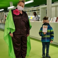 „Theaterkobold Adele“ überreichte Noah Kratzenberg eine DVD. Er war das erste Kind, das sich eine der kostenlosen DVDs in der Bücherei abholte.