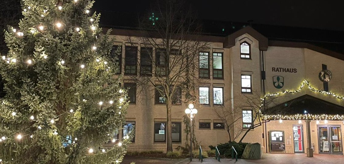 Blick auf den weihnachtlich beleuchteten Rathausplatz Lohfelden mit Weihnachtsbaum und Lichtern am Rathaus.