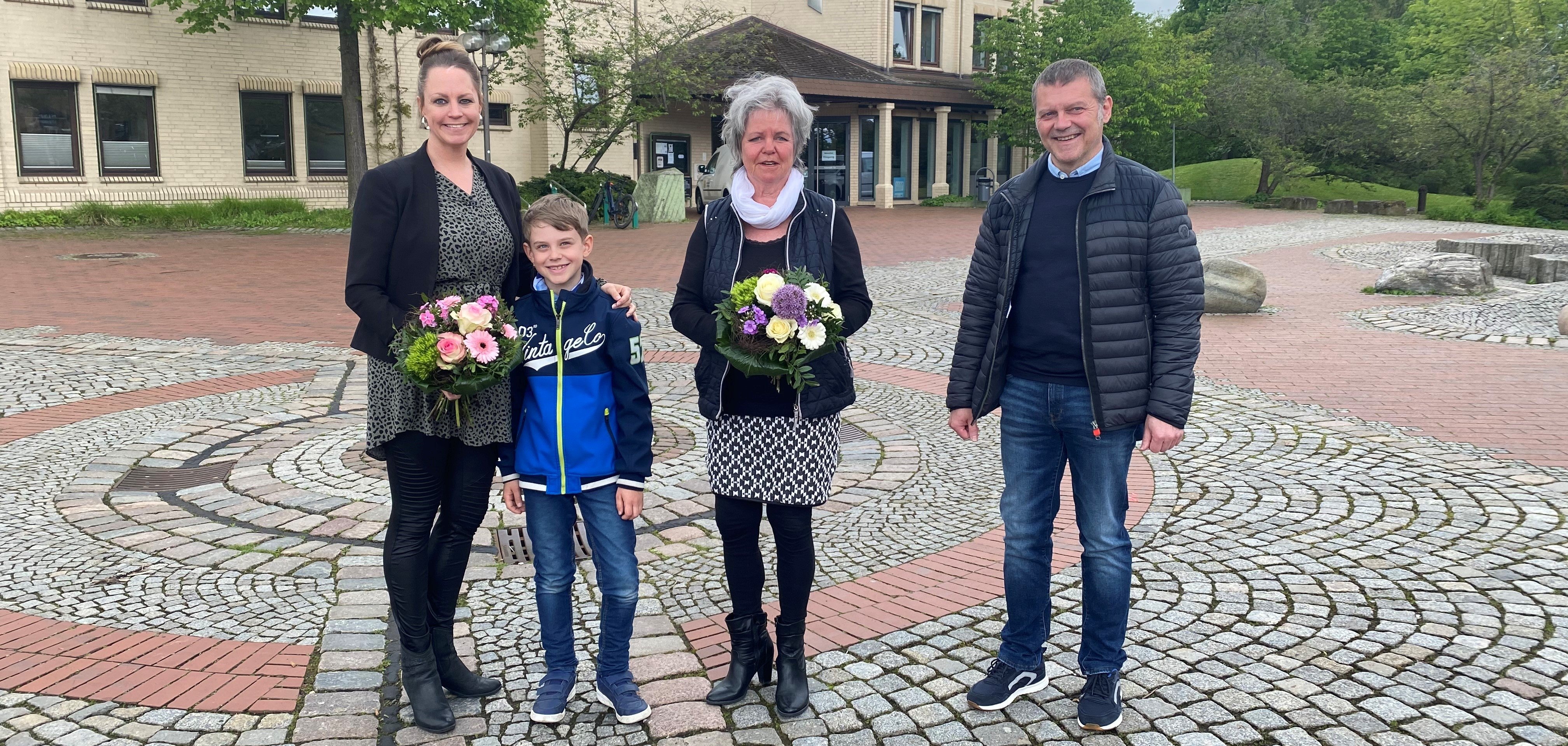 Als kleines „Dankeschön“ zum Ende der Aktion überreichte der Erste Beigeordnete der Gemeinde Lohfelden, Norbert Thiele (r.) an die Gestalterinnen der „Lichtblicke“ im Blickpunkt Lohfelden, Gaby Pech-Juhlke (M.) und Julia Juhlke (l.) einen Blumenstrauß. Elias freute sich mit seiner Mutter und seiner Großmutter. Die Lichtblicke werden demnächst als Buch erscheinen.