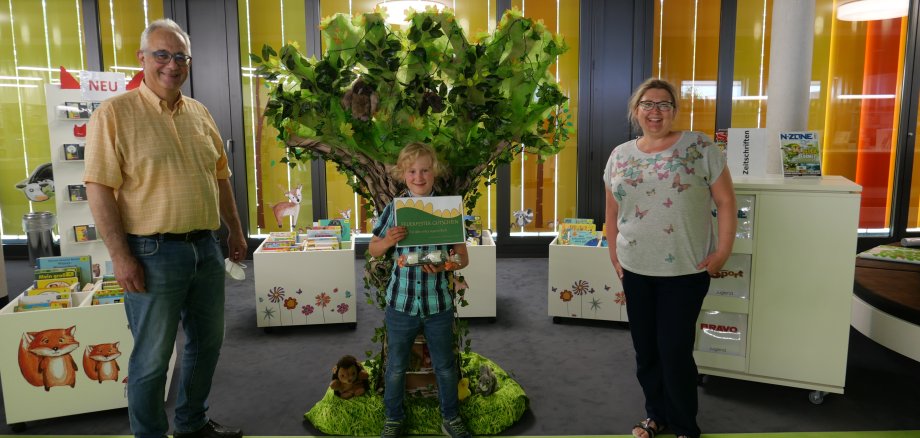 Leiterin der Gemeinde- und Schulbücherei Sabrina Bieberstedt (r.) gratulierte am 17.06. gemeinsam mit Bürgermeister Uwe Jäger (l.) dem jungen Lohfeldener Kinderbuchautor Mathis Strüwing (M.) zu seinen Büchern und überreichte ihm einen Gutschein für den Druck eines großen Sammelbandes seiner Drachengeschichten sowie ein Fauchie-Marketingpaket.