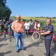 Das Band wird durchschnitten und der neue Radweg ist eingeweiht: Bürgermeister der Gemeinde Lohfelden Uwe Jäger (l.) und Bürgermeister der Gemeinde Kaufungen Arnim Roß würdigen den reibungslosen Ablauf des Gemeinschaftsprojektes und begrüßen den Radwegelückenschluss zwischen den beiden Gemeinden. Im Hintergrund die Lohfeldener Teilnehmerinnen und Teilnehmer.