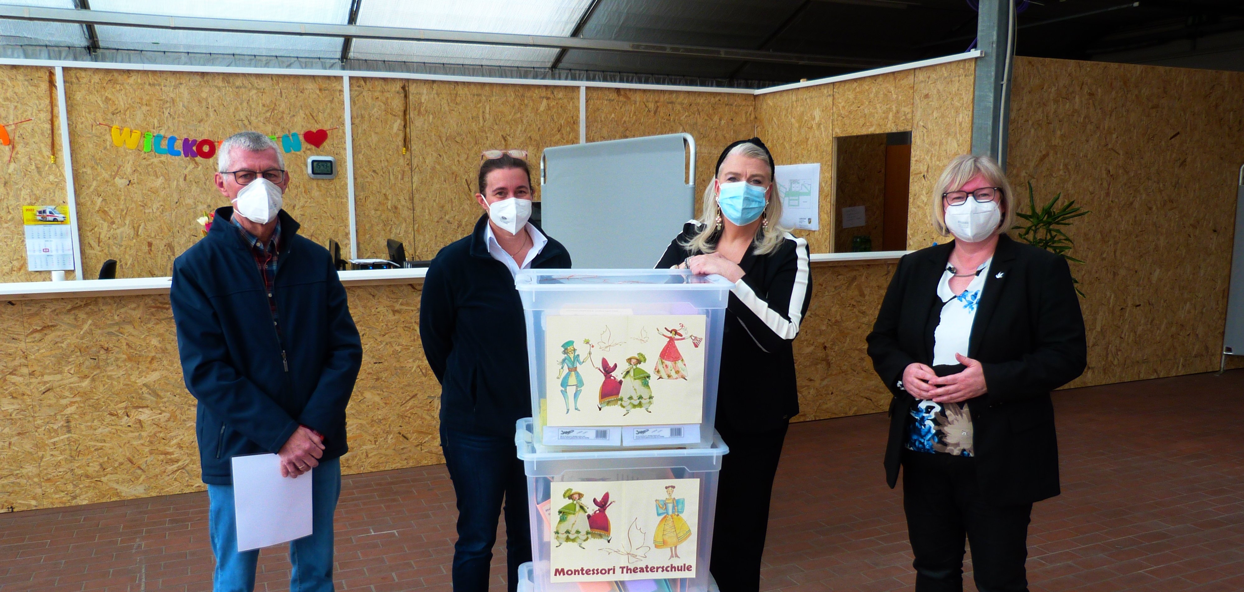 Auf dem Foto sieht man von links nach rechts Heinz-Jürgen Ilse (FSK Lohfelden), Judith Ehret (ASB Nordhessen), Petra Sturm-Thomas (Montessori-Theaterschule) und Vizelandrätin Silke Engler im Eingangsbereich der Flüchtlingsunterkunft im ehemaligen Gartencenter Hornbach in Lohfelden.