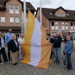 Gemeinsam hissten die Teilnehmenden als Zeichen der Solidarität am 05.05. die offizielle „Flagge der Überwindung und der Behinderung“ vor dem Rathaus.