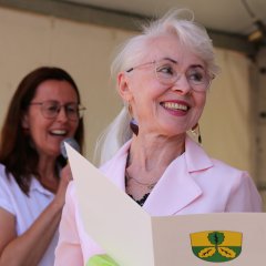 Nach seinem Grußwort verlieh der Verwaltungschef (r.) die Ehrennadel an Lubov Zufall-Korsakova (l.).  