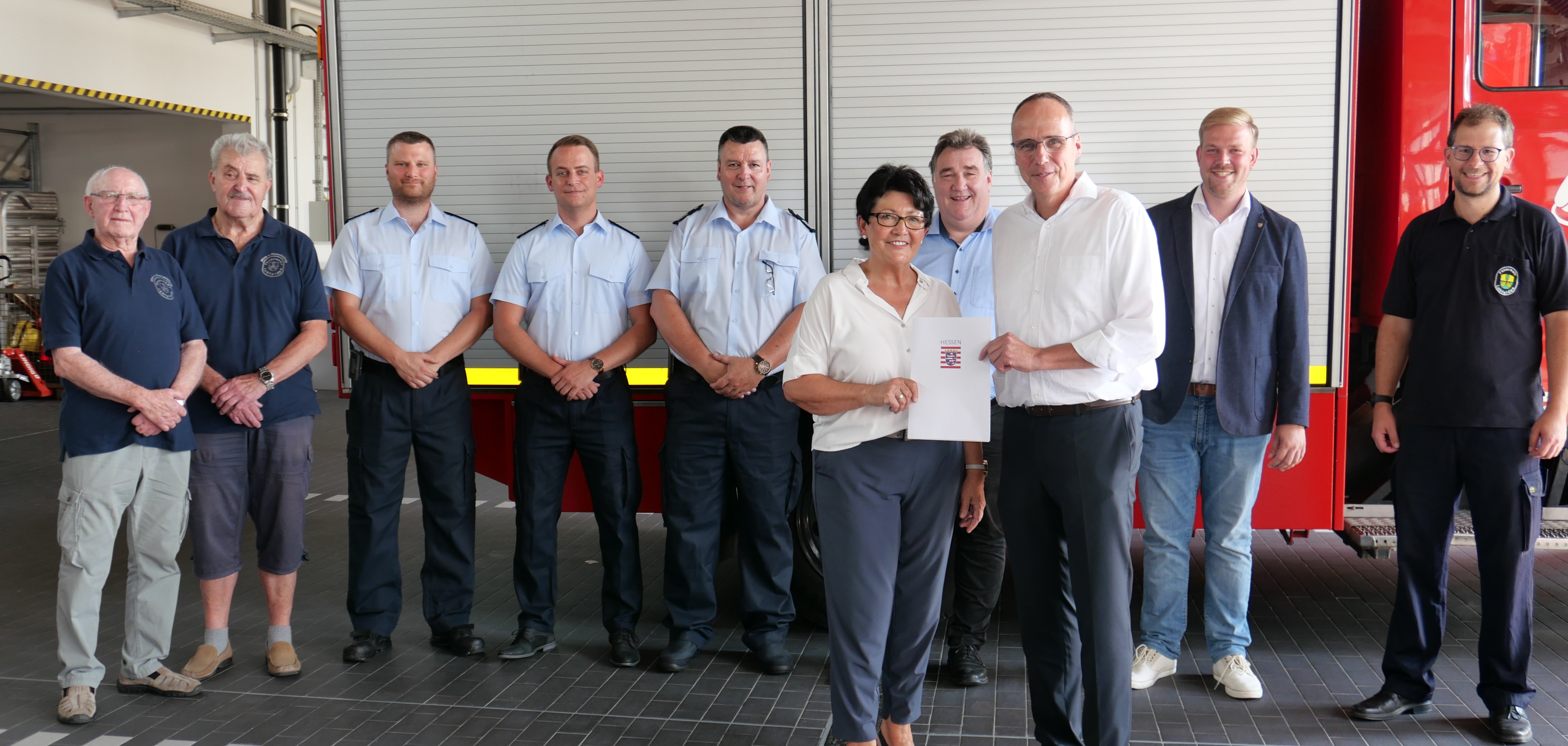 Staatsminister Peter Beuth überreichte einen Förderbescheid über 61.250,00 € für ein neues Feuerwehrfahrzeug der Gemeinde Lohfelden an die Erste Beigeordnete, Bärbel Fehr. Mit dabei waren v.l.n.r. Feuerwehrsenioren Georg Günther und Rudi Gippert, die stv. Gemeindebrandinspektoren Markus Orth und Jan Moog, Gemeindebrandinspektor Michael Kahl, Regierungspräsident Mark Weinmeister, Landtagsabgeordneter Florian Schneider und Jugendwart Boris Fiegand.