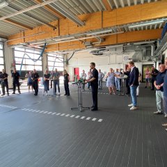 Blick in die Fahrzeughalle im Feuerwehrhaus Lohfelden mit den Gästen der kleinen Feierstunde.