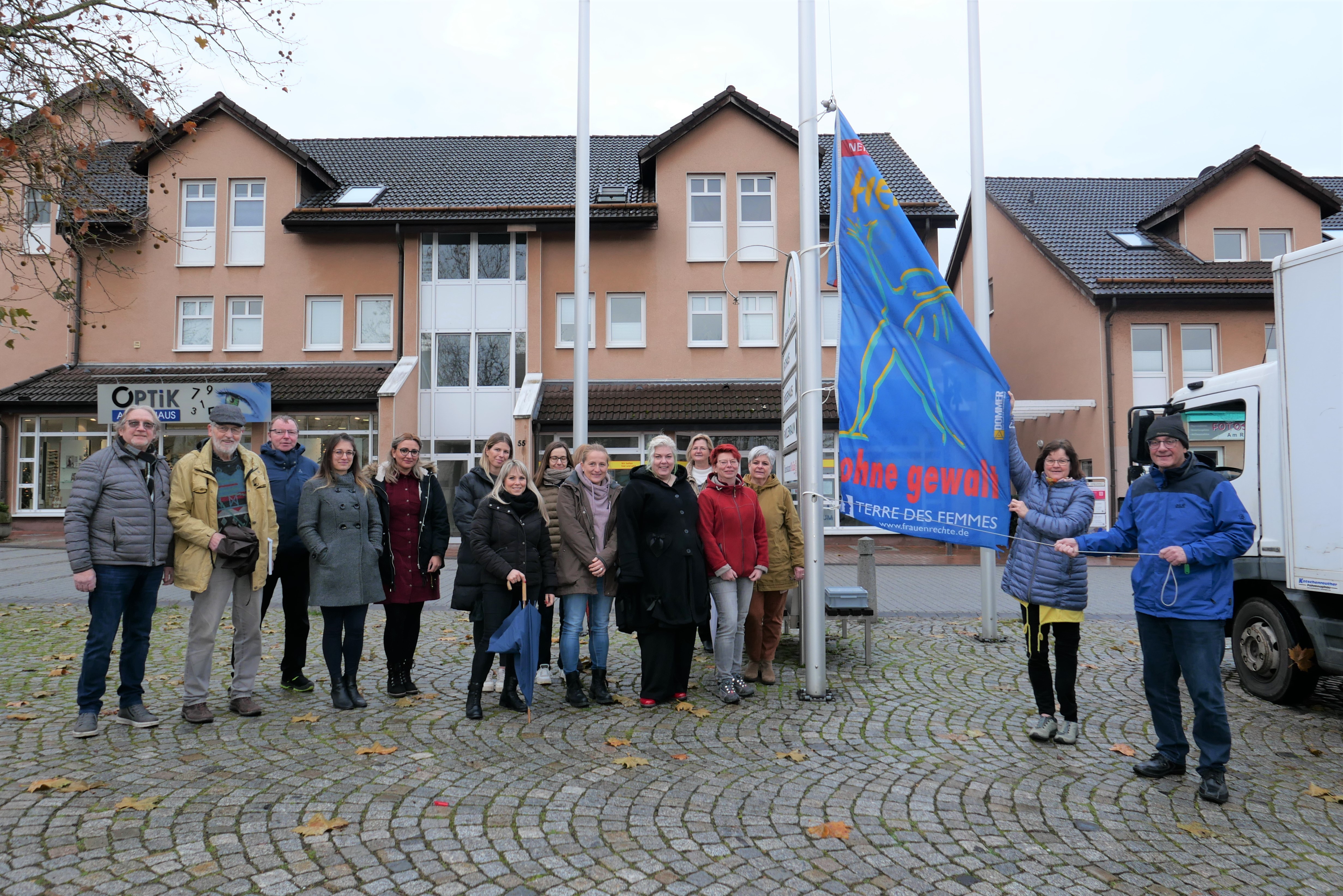 Interne Frauenbeauftragte Sabine Wagner (2.v.r.) und Bürgermeister der Gemeinde Lohfelden, Uwe Jäger (r.), hissten am 25.11. gemeinsam mit anderen Gästen der Veranstaltung die Fahne „Frei leben – ohne Gewalt“ als Zeichen zur Beseitigung von Gewalt gegen Frauen auf dem Dr.-Walter-Lübcke-Platz vor dem Rathaus.