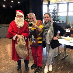 Die für die Organisation der Weihnachtsfeier verantwortliche Rathaus-Mitarbeiterin Katharina Schaub zusammen mit Trompetenspieler Jürgen Sprenger (M.) und dem Weihnachtsmann Arndt Grodzicki.