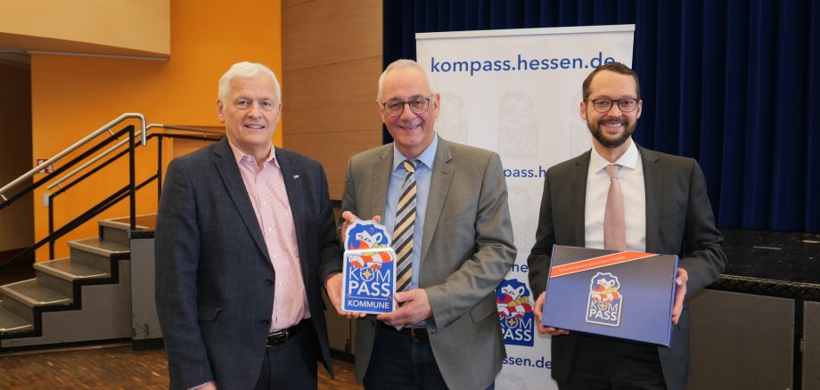 Mit Freude nahm Bürgermeister Uwe Jäger (M.) das Begrüßungsschild von Jan Schneider, Leiter der Stabsstelle „Gemeinsam Sicher In Hessen“ (r.), und Polizeipräsident Konrad Stelzenbach entgegen.