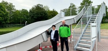 Erste Beigeordnete Bärbel Fehr und Schwimmmeister Bastian Paßau präsentieren die neue Breitwellenrutsche.