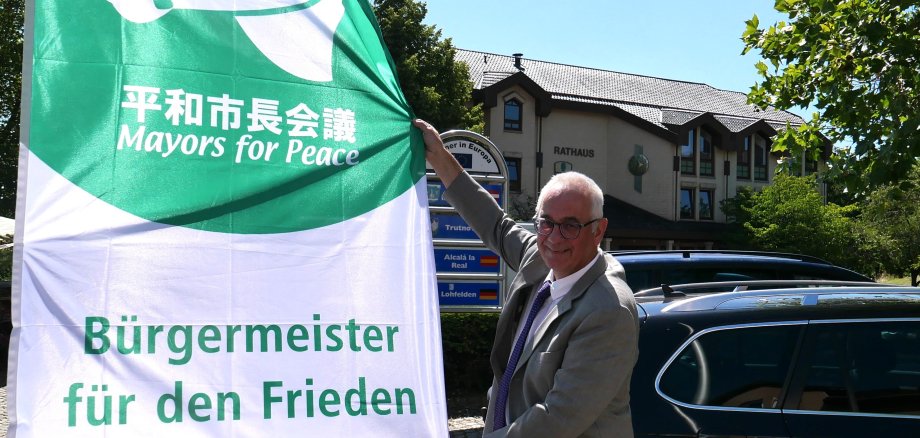 Ein Zeichen für den Frieden: Bürgermeister Uwe Jäger hisste am 08.07. die Fahne der Mayors for Peace auf dem Dr.-Walter-Lübcke-Platz.