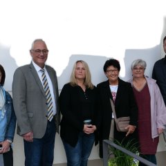 Auf dem Foto ist Bürgermeister der Gemeinde Lohfelden, Uwe Jäger (2.v.l.), zu sehen, der am 04.10. der Leiterin der KiTA Lo-Hüpfer, Claudia Pristl (3.v.l.), gemeinsam mit Erster Beigeordneten Bärbel Fehr (3.v.r.), Leiter des Fachbereichs Verwaltung und Ordnung, Kai Hast (r.), der stellv. Leiterin des Fachbereichs Verwaltung und Ordnung, Tanja Hammer (l.) sowie der Projektverantwortlichen und stellvertretenden Leiterin des Fachbereichs Bauen und Wohnen, Jutta Kothe (2.v.r.), zur Eröffnung der neuen KiTa Lo-Hüpfer gratulierte.