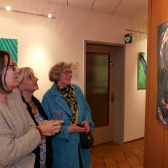 Ursula Hartwig, Pia Kirchner und Larysa Börner (v.l.) betrachten interessiert die abwechslungsreichen und farbenintensiven Bilder.