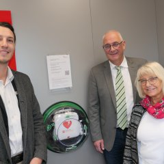 Bürgermeister Uwe Jäger (M.) begutachtete gemeinsam mit dem verantwortlichen Architekt vom Gebäudemanagement der Sparkasse, Fabian Jerusalem, und Renate Schneider von der Praxis für Physiotherapie „Sport Life“, den frisch umgezogenen Lebensretter in der SB-Stelle der Kasseler Sparkasse in der Welleröder Straße 1.