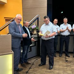 Uwe Jäger (l.) und Norbert Thiele (2.v.l.) sprachen dem ehemaligen Gemeindebrandinspektor, Michael Kahl (M.), sowie seinen Kameraden im Hintergrund, Dank und Anerkennung für ihre geleisteten Dienste aus.   