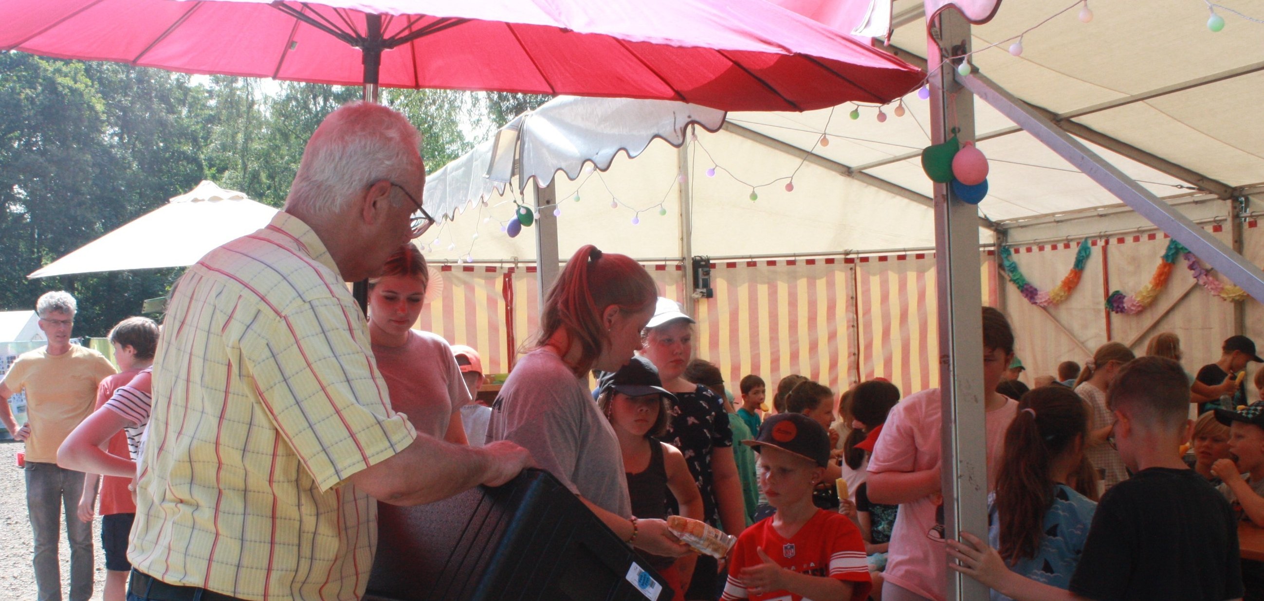 „Eiszeit“ beim Ferien-FEZ – Lohfeldens Bürgermeister Uwe Jäger (l.) verteilte kalten Nachtisch an die Mädchen und Jungen.