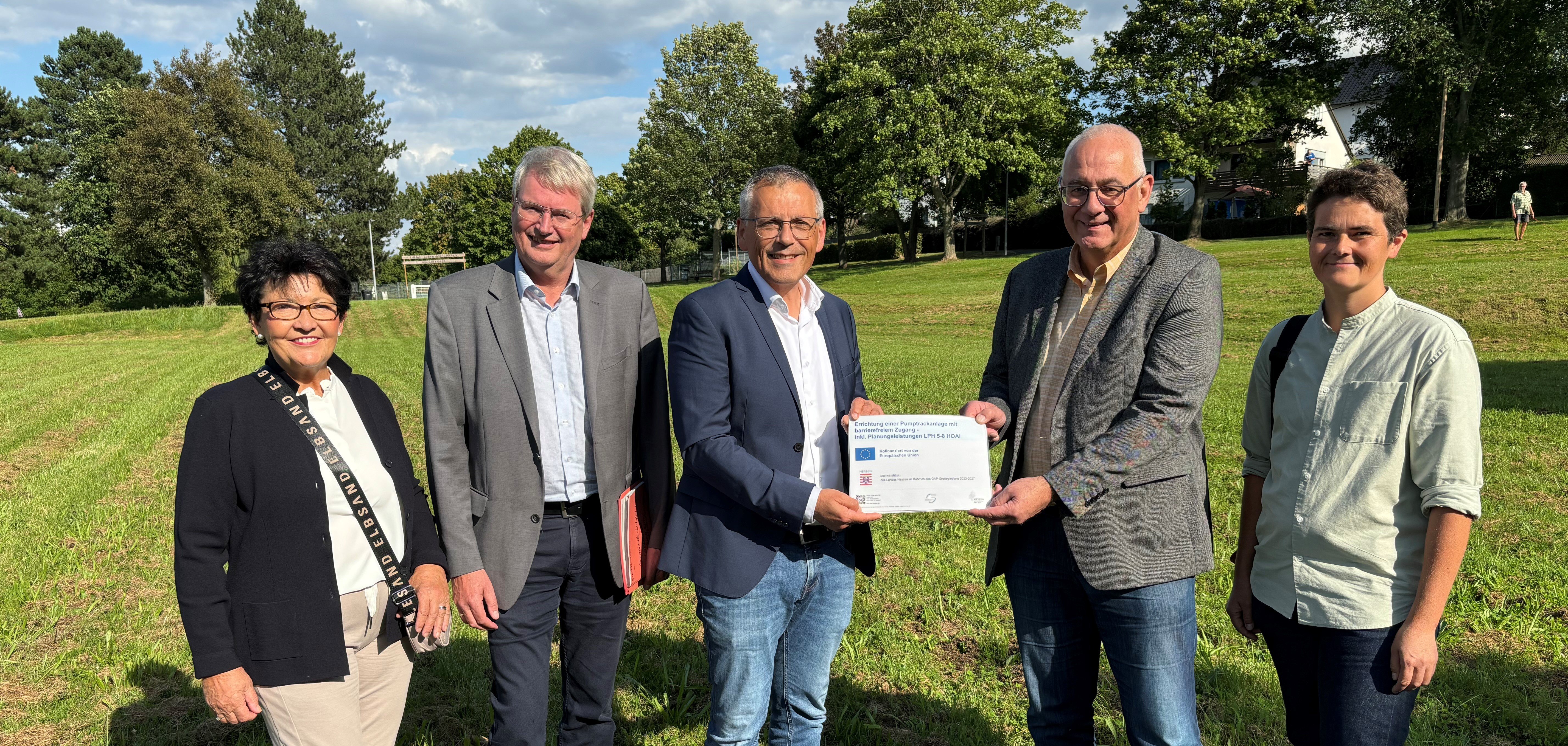 Am Projektstandort am Rande des Nordhessenstadions wurde der LEADER-Förderbescheid zur Errichtung einer Pumptrackanlage übergeben: (v.li.) Bärbel Fehr (erste Beigeordnete Lohfelden), Peter Nissen (Fachbereichsleitung Servicezentrum Regionalentwicklung), Landrat Andreas Siebert, Lohfeldens Bürgermeister Uwe Jäger und Dr. Christine Rüther (stv. Sprecherin des LEADER-Entscheidungsgremiums).