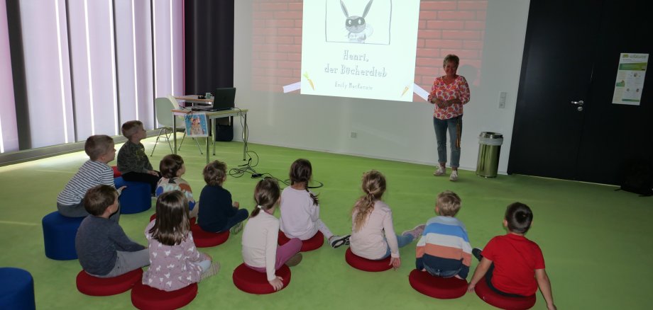 Die kleinen Besucherinnen und Besucher lauschen der Geschichte von Henri, dem Bücherdieb.
