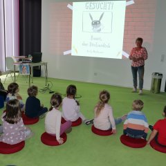 Die kleinen Besucherinnen und Besucher lauschen der Geschichte von Henri, dem Bücherdieb.