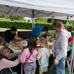 Bastelnde Kinder an einem Tisch unter einem Pavillon