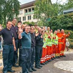 Frauen und Männer in Uniformen stehen in einer Reihe.