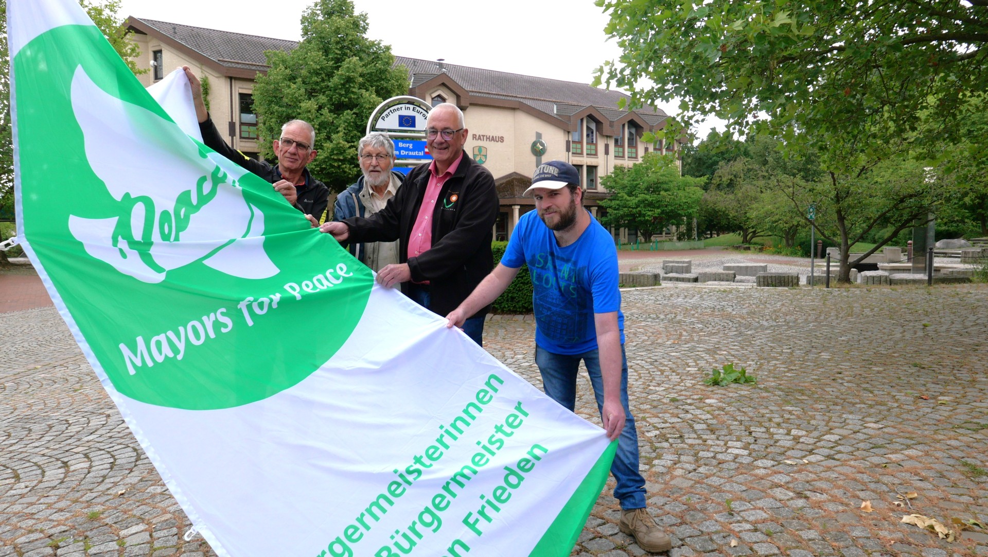 Bürgermeister Uwe Jäger (2.v.r.) hisste am 8. Juli die Flagge des Bündnisses „Mayors for Peace“.