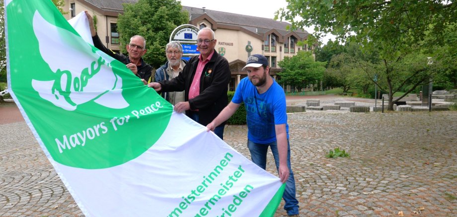 Bürgermeister Uwe Jäger (2.v.r.) hisste am 8. Juli die Flagge des Bündnisses „Mayors for Peace“.
