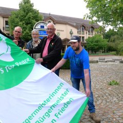 Bürgermeister Uwe Jäger (2.v.r.) hisste am 8. Juli die Flagge des Bündnisses „Mayors for Peace“.