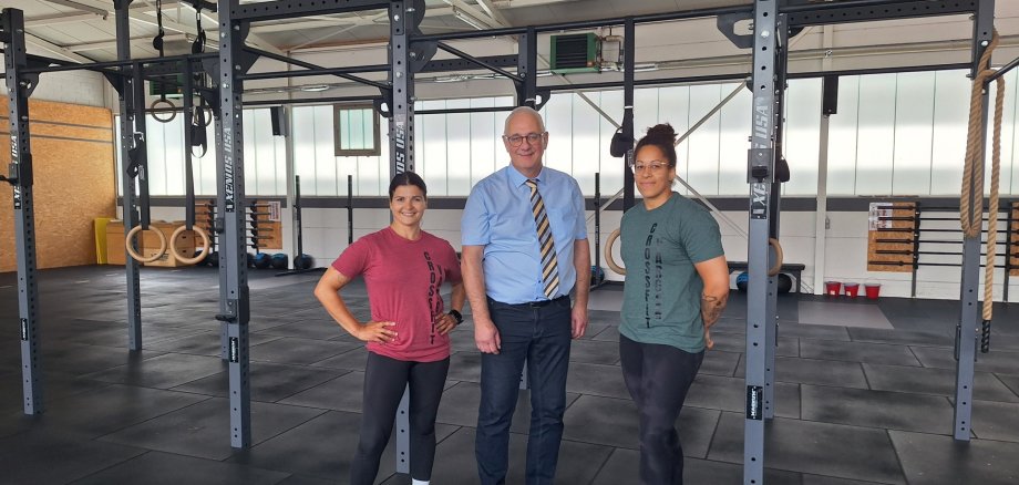 Bürgermeister Uwe Jäger auf Wirtschaftsbesuch im Fitnessstudio CrossFit Vargen gemeinsam mit den beiden Inhaberinnen Samira Hamdi und Emely Camara.