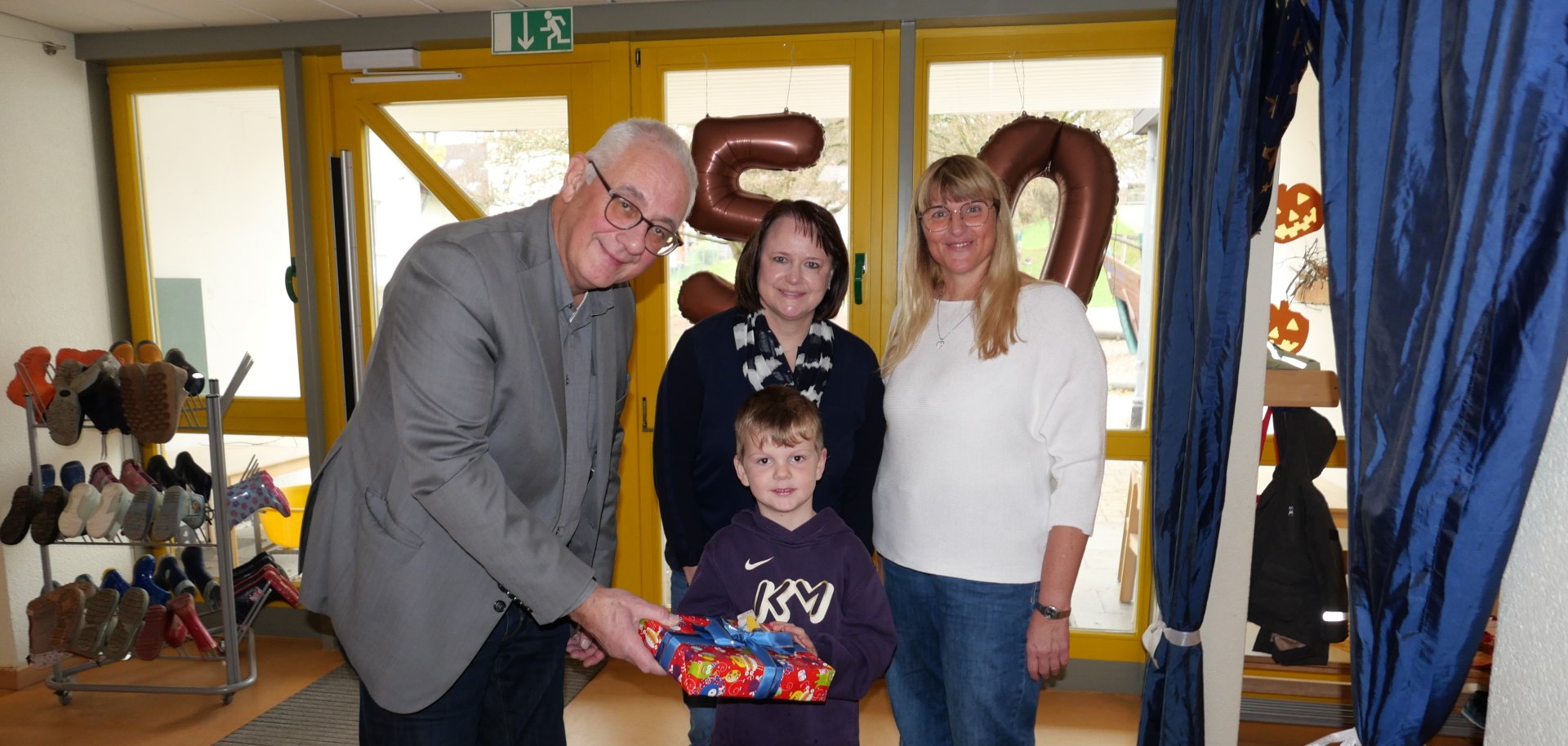 Bürgermeister Uwe Jäger übergibt gemeinsam mit Tanja Hammer, Leiterin des Sachgebiets Kindertagesstätten (M.), und komm. Leiterin der KiTa Ochshausen, Sandra Schiffmann, eines der Geschenke stellvertretend für alle Kinder der KiTa Ochshausen an Vorschulkind Lukas Bürgermeister Uwe Jäger übergibt gemeinsam mit Tanja Hammer, Leiterin des Sachgebiets Kindertagesstätten (M.), und komm. Leiterin der KiTa Ochshausen, Sandra Schiffmann, eines der Geschenke stellvertretend für alle Kinder der KiTa Ochshausen an Vorschulkind Lukas