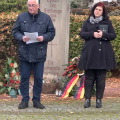 Bürgermeister Uwe Jäger mit Pfarrerin Andrea Fugmann-Szugfill stehen vor dem Ehrenmal auf dem Friedhof.