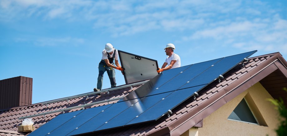 Workers building solar panel system on roof of house. Installers carrying photovoltaic solar module Workers building solar panel system on roof of house. Installers carrying photovoltaic solar module