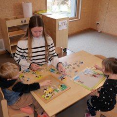 Konzentriert am Werk: Die zukünftige Erzieherin puzzelt mit zwei Kindern.