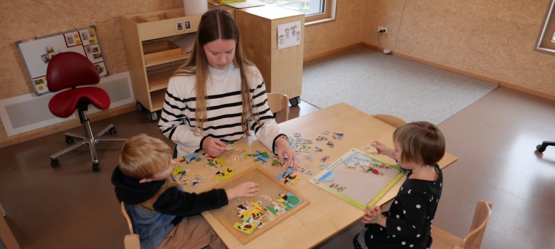 Konzentriert am Werk: Die zukünftige Erzieherin puzzelt mit zwei Kindern. Konzentriert am Werk: Die zukünftige Erzieherin puzzelt mit zwei Kindern.