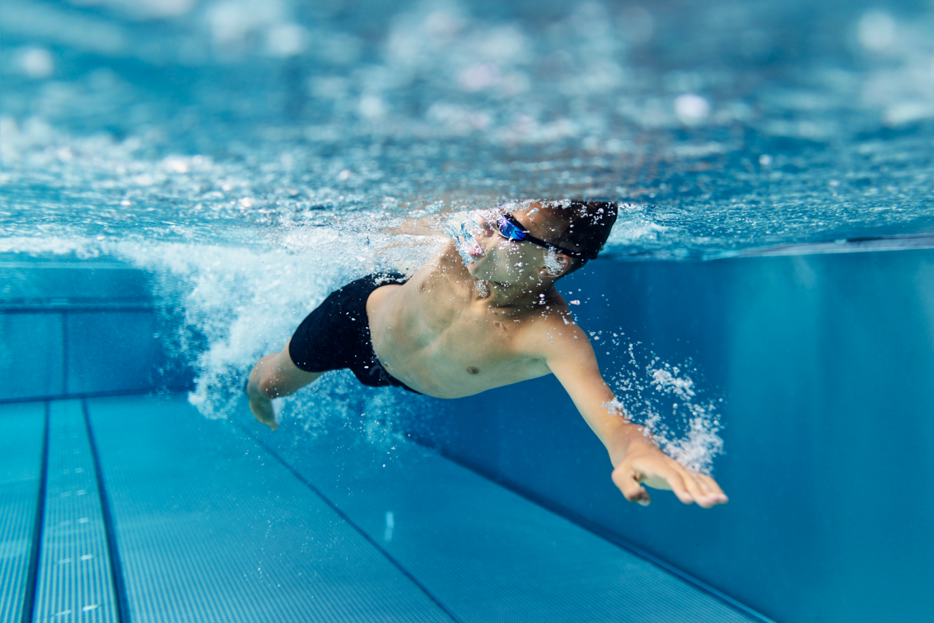 Junge schwimmt im Freibad und krault Junge schwimmt im Freibad und krault