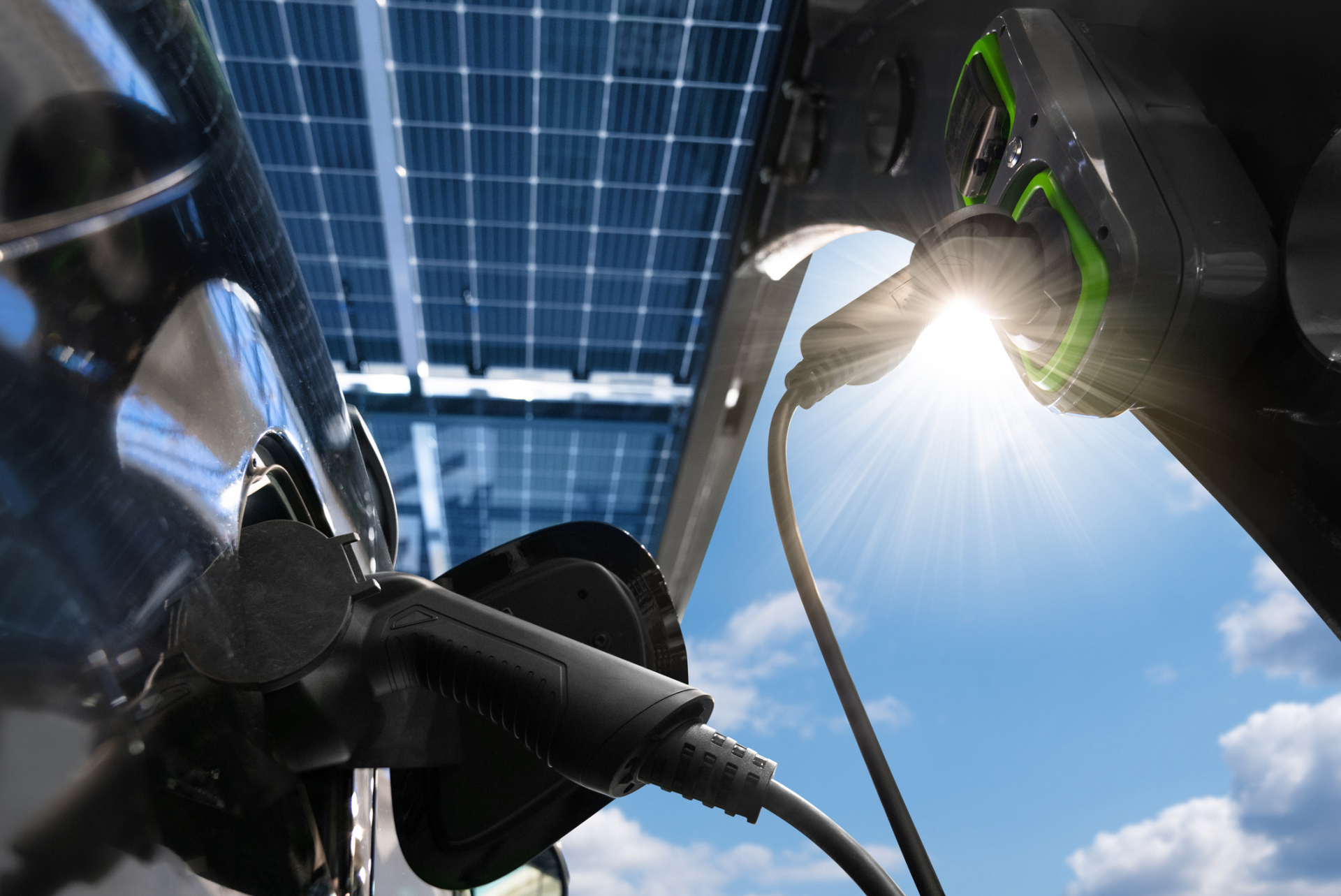 Electric car is charged from a charging station that takes energy from solar panels. Solar carport. Close up Electric car is charged from a charging station that takes energy from solar panels. Solar carport. Close up