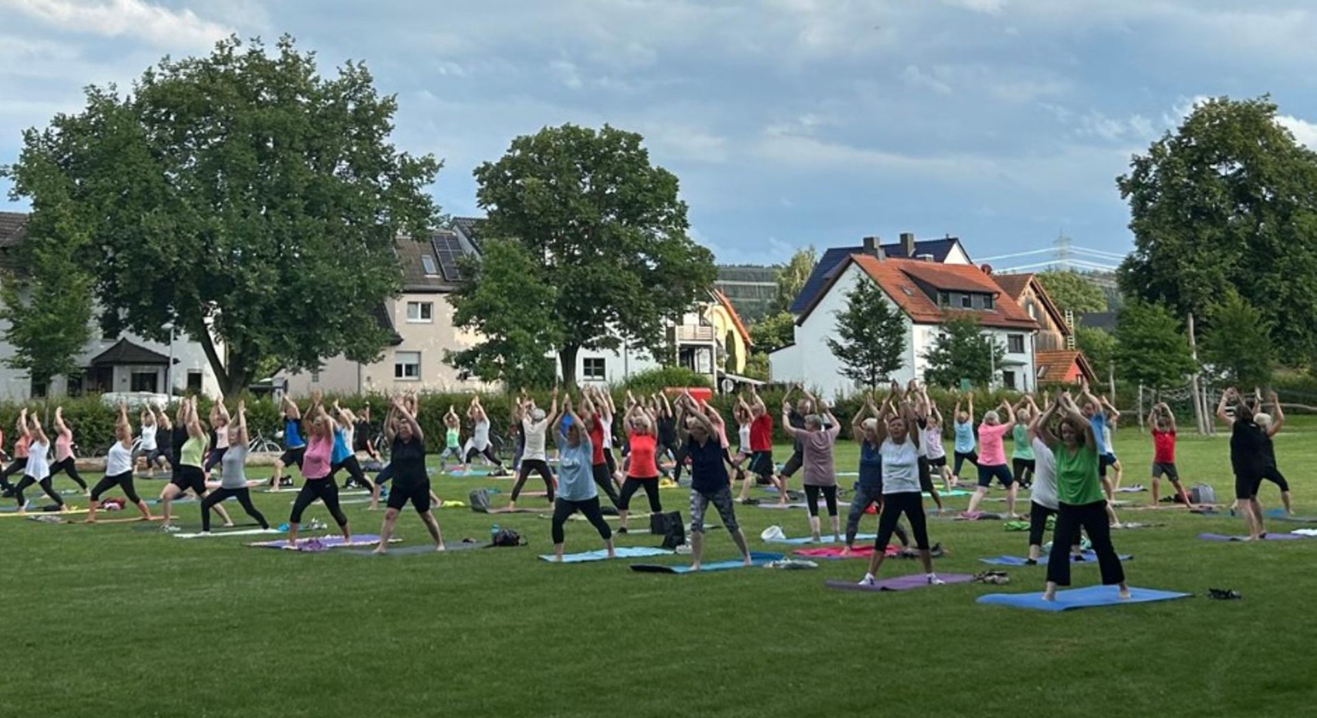 Yogasommer in Lohfelden Blick auf eine Wiese, wo viele Menschen Yoga-Übungen absolvieren