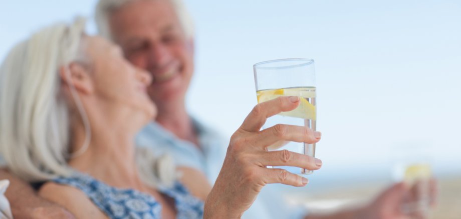 Senior couple drinking water on beach