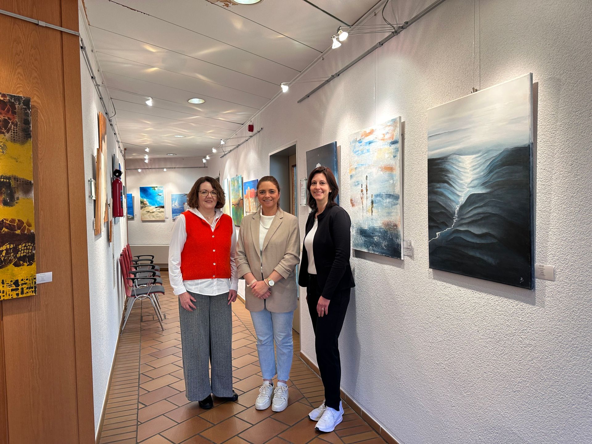 Senioren-Beauftragte Katharina Schaub steht im Rathausflur zusammen mit zwei Kolleginnen.