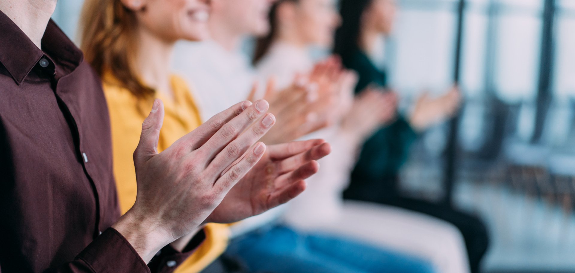 Businesspeople applauding during a seminar in conference hall.