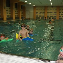 Blick in das Lehrschwimmbecken in der Wilhelm-Richter-Halle mit drei kleinen Schwimmern auf Schwimmnudeln.