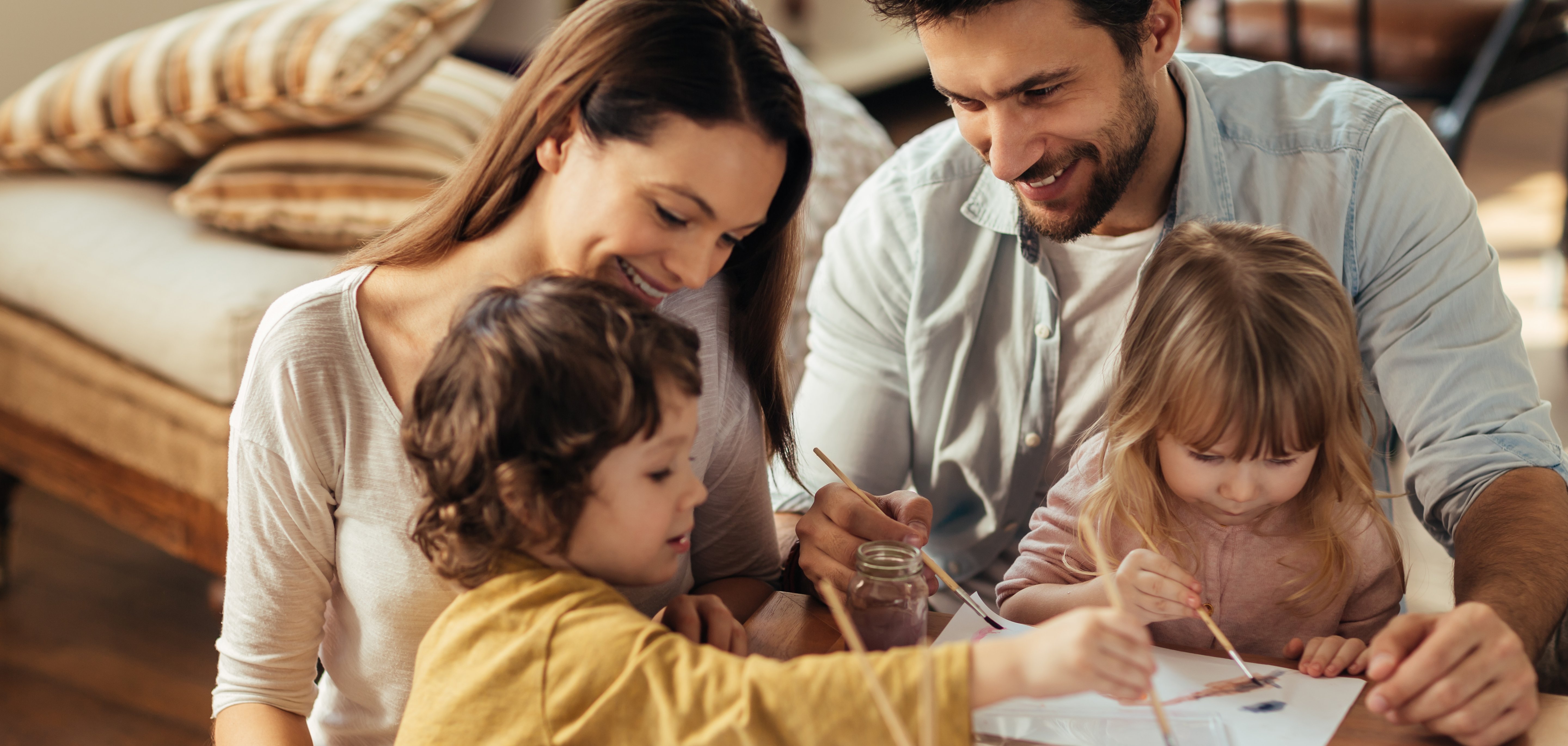 Familie mit zwei Kindern. Familie mit zwei Kindern spielen am Couchtisch.