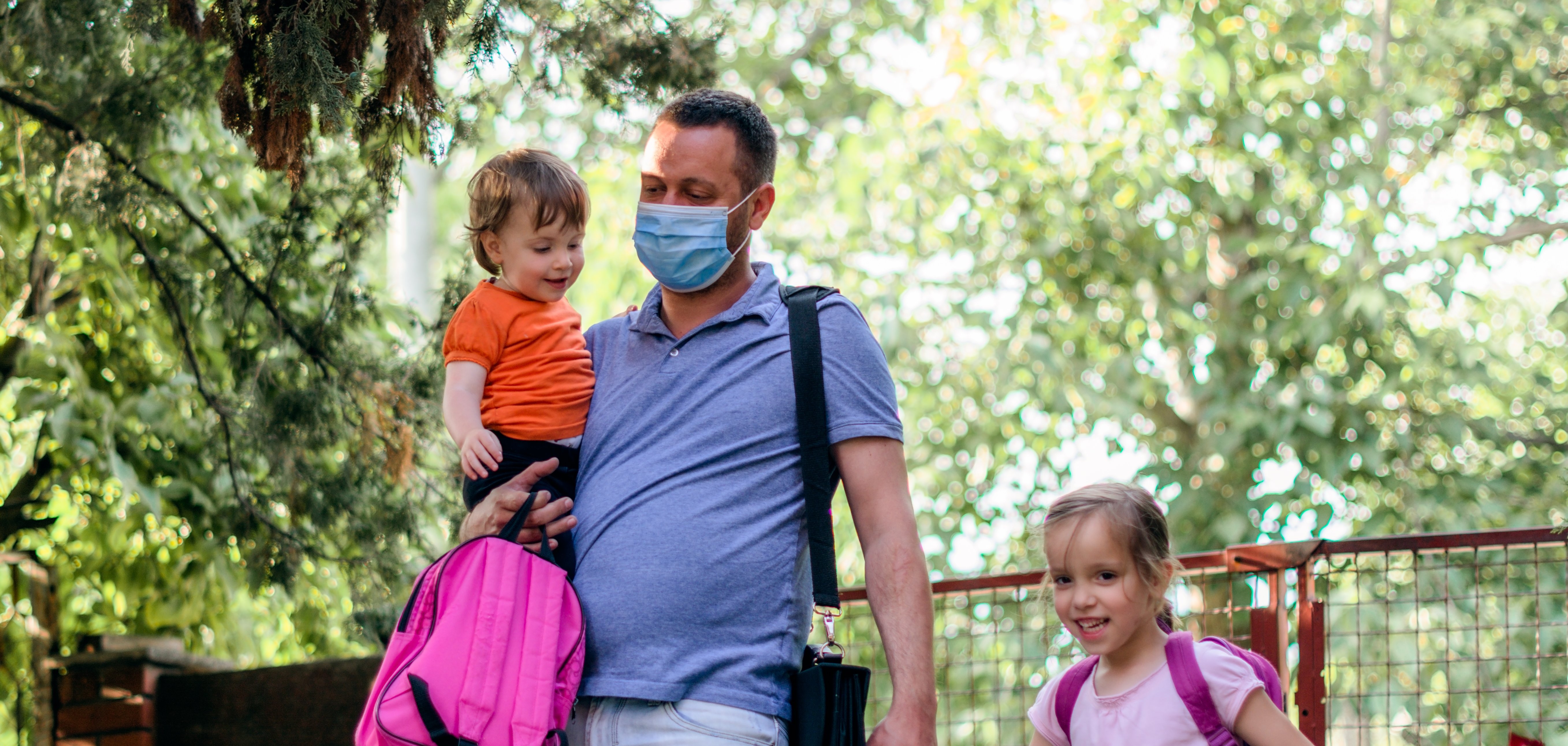 Ein Vater bringt zwei Kinder in der Kindertagesstätte.